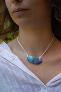 light blue ceramic necklace with a pendant replicating holding hands. Princess style necklace.