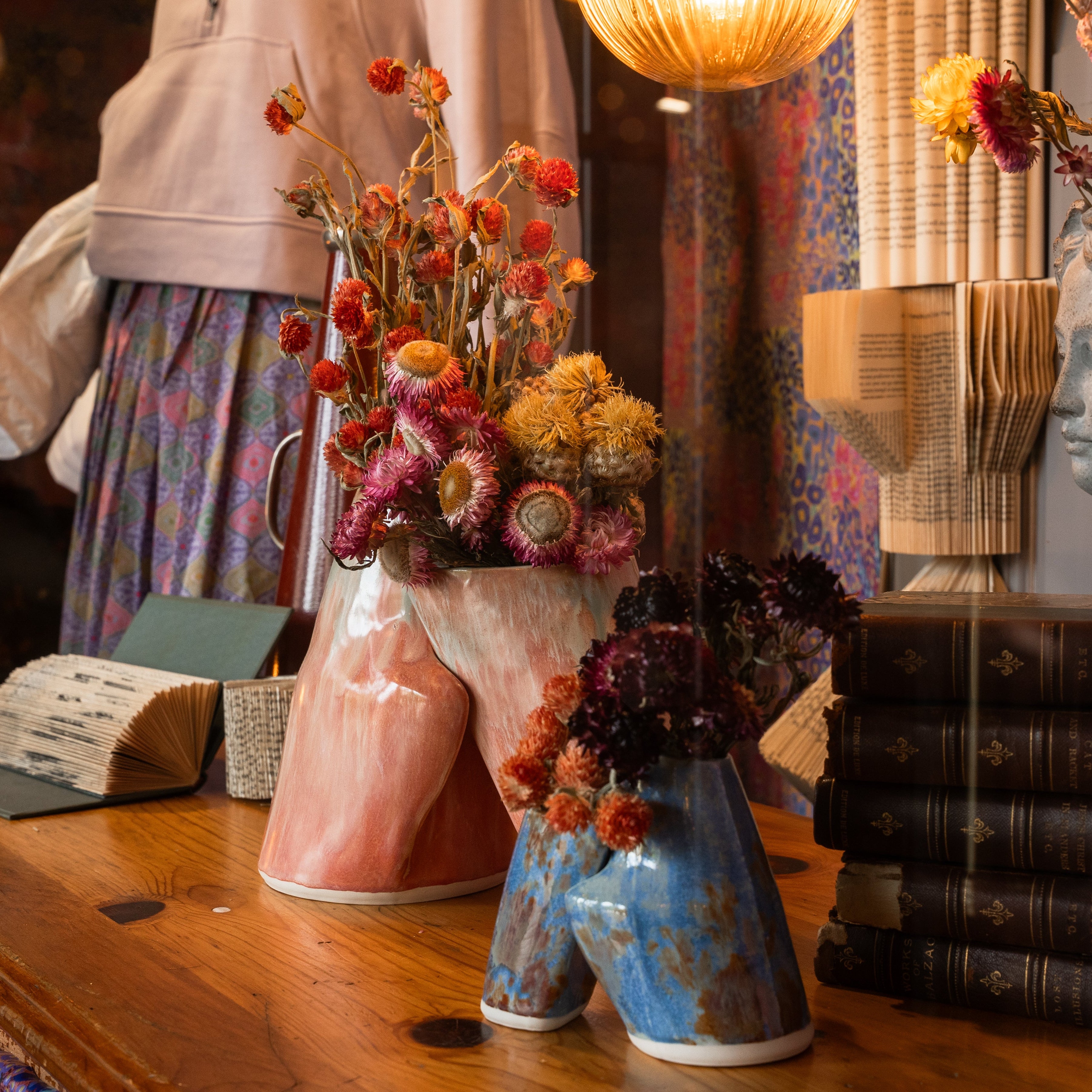 Embrace Vases from Margaret Stickler's LeanOnMe collection photographed by Brayan Mesa on display at the Harvard COOP alongside artwork by Boston Pollen in Cambridge, MA.